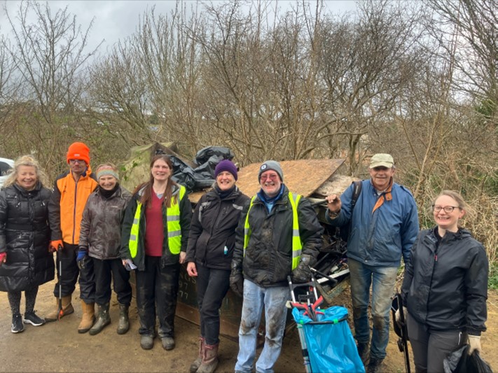 Group of a dozen people in work clothes, some in hi viz, smiling.